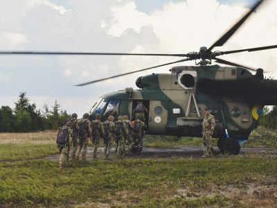 Десантники зі зброєю та спорядженням виконують стрибки з парашутом  
