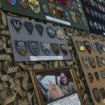 На фото — фрагмент виставки колекції нарукавних знаків американського добровольця Стіва Андре, представленої у Національний військово-історичний музей України. На стендах розміщені десятки шевронів і патчів різних підрозділів, акуратно згрупованих та закріплених на камуфльованому тлі.