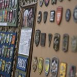 На фото — фрагмент виставки колекції нарукавних знаків американського добровольця Стіва Андре, представленої у Національний військово-історичний музей України. На стендах розміщені десятки шевронів і патчів різних підрозділів, акуратно згрупованих та закріплених на камуфльованому тлі.