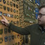 На фото — фрагмент виставки колекції нарукавних знаків американського добровольця Стіва Андре, представленої у Національний військово-історичний музей України. На стендах розміщені десятки шевронів і патчів різних підрозділів, акуратно згрупованих та закріплених на камуфльованому тлі.