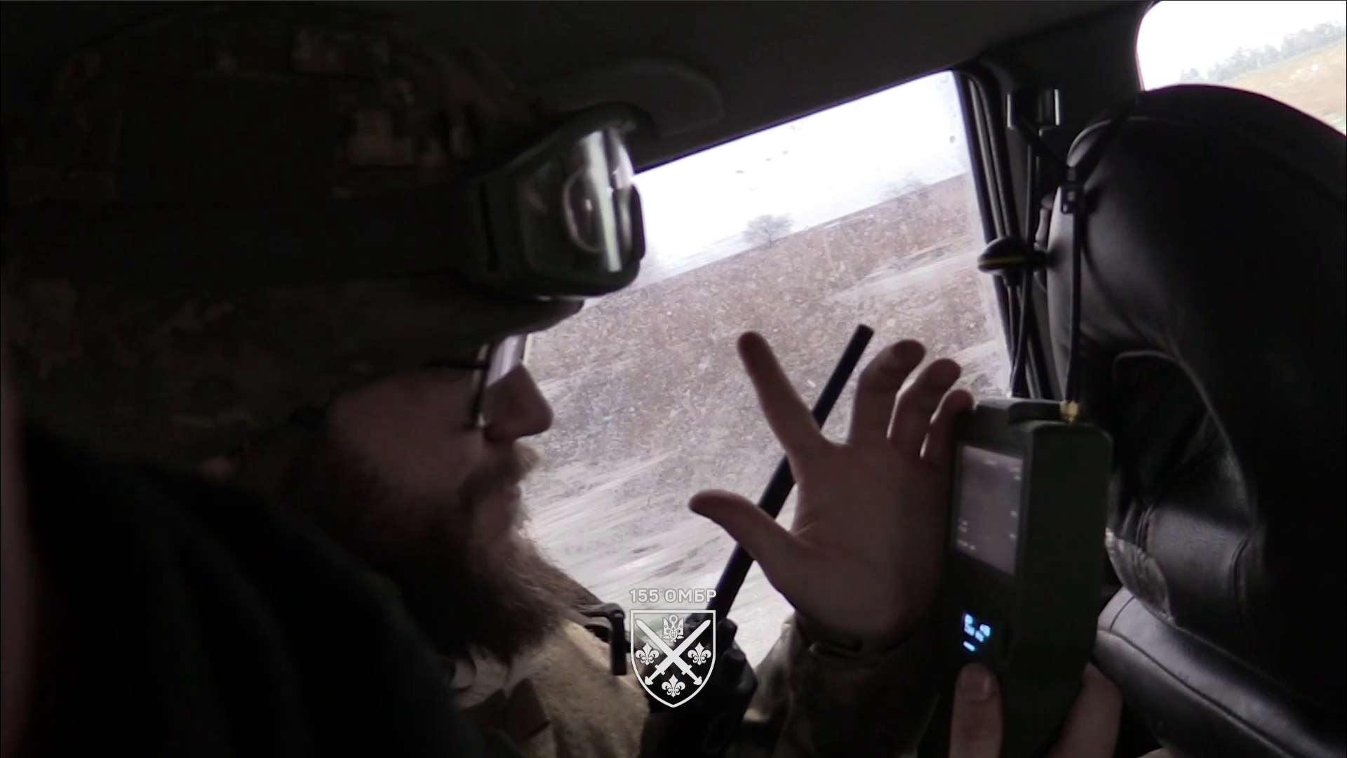 Боєць сидить у авто і тримає в руках детектор дронів