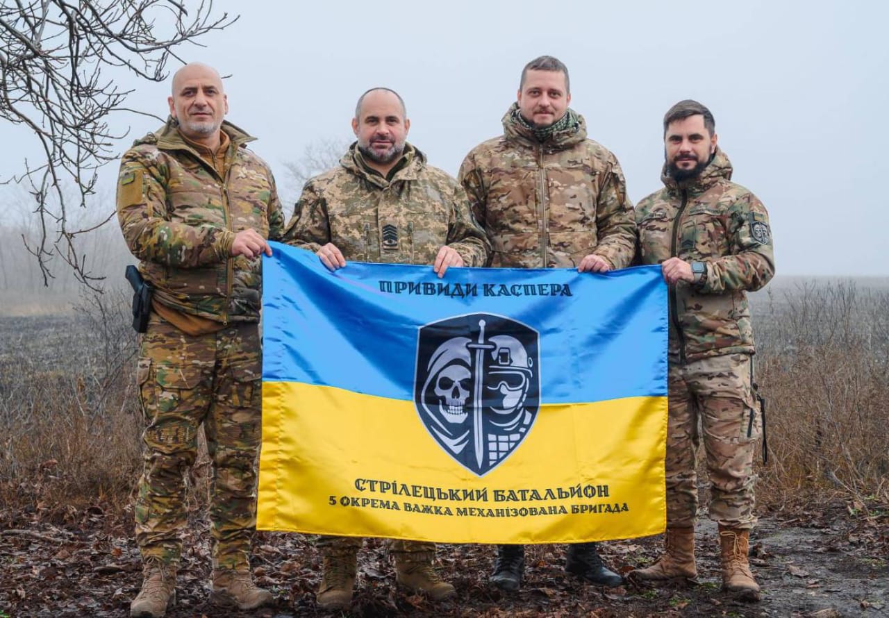 Військовослужбовці стрілецького батальйону 5-ї окремої важкої механізованої бригади тримають свій бойовий стяг.