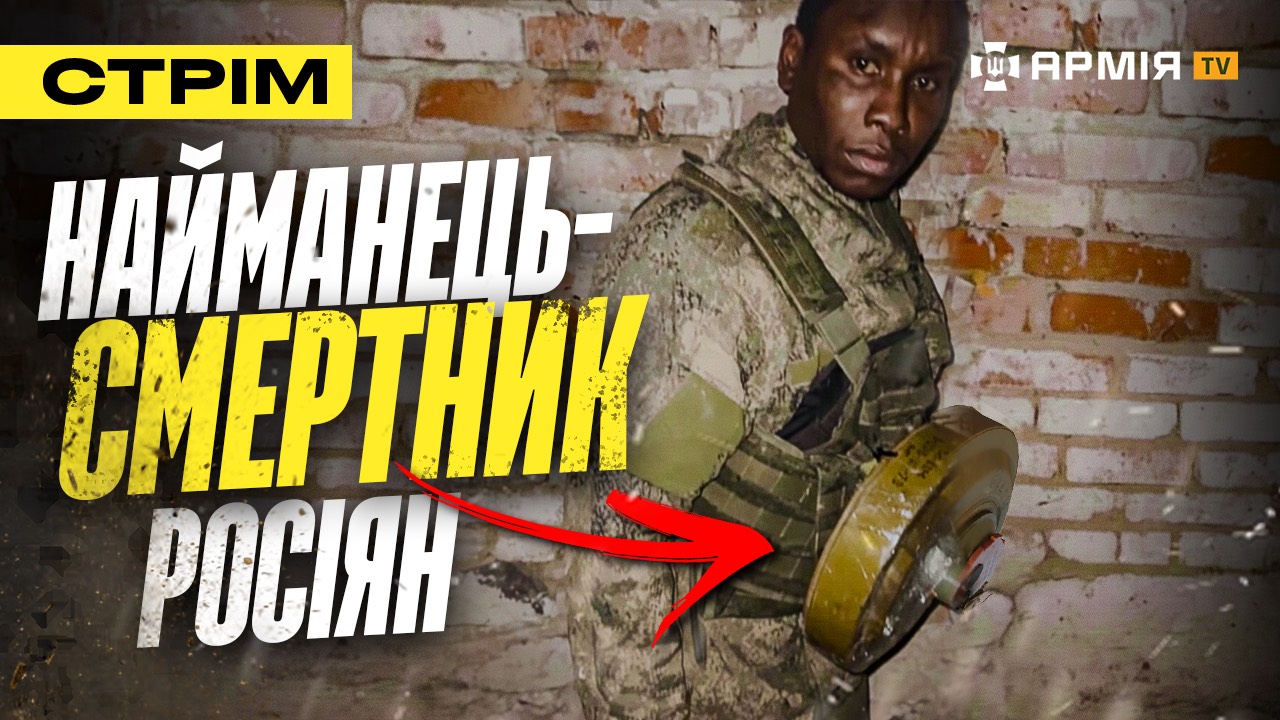 Солдат у камуфляжі тримає протитнкову міну на фоні цегляної стіни