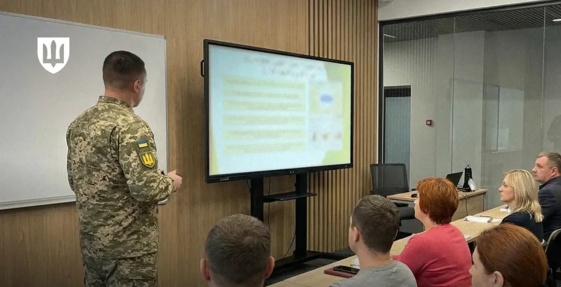 Люди сидять перед електронною дошкою