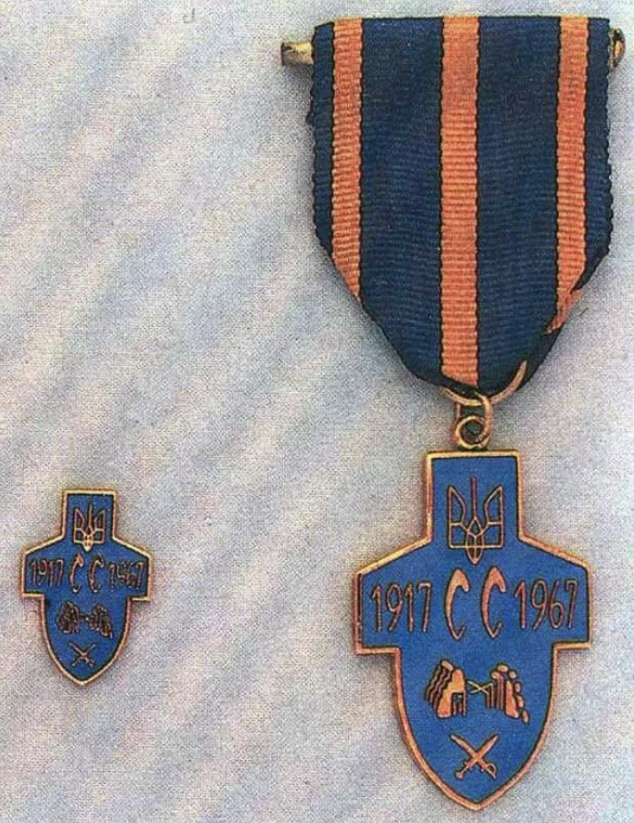 Показано хрестоподібну відзнаку на стрічці з синіми та помаранчевими смугами поруч із мініатюрним значком. На медалі зображено тризуб і дати 1917–1967 з додатковими символами.