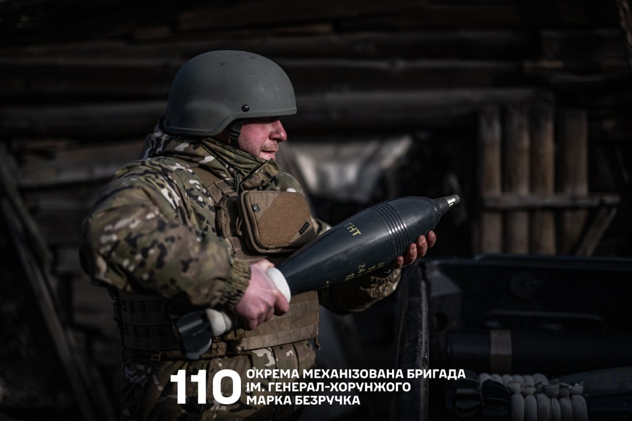 Боєць несе міну для міномета