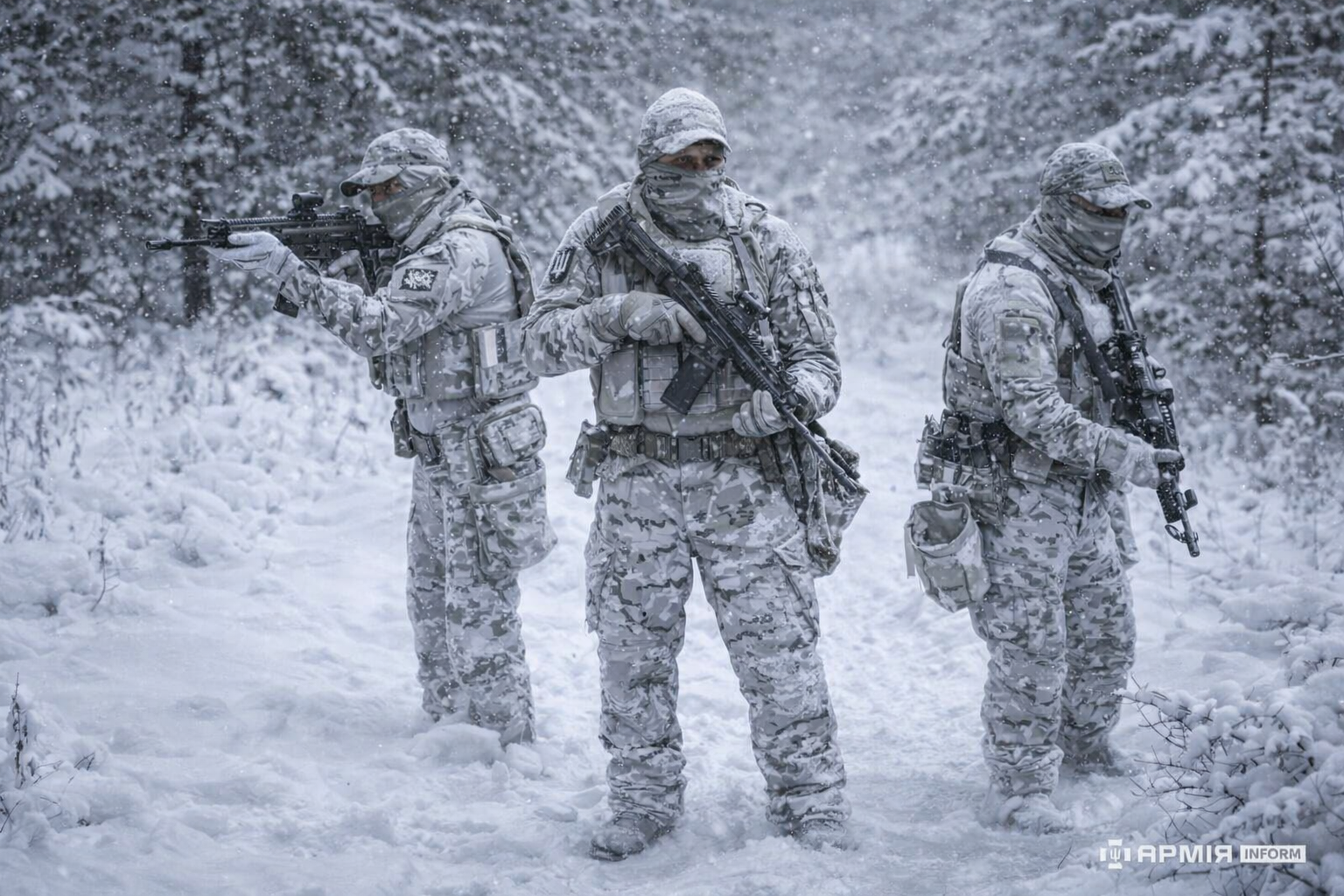 Військові ГУР МОУ у засніженому лісі у маскувальних халатах зі зброєю.