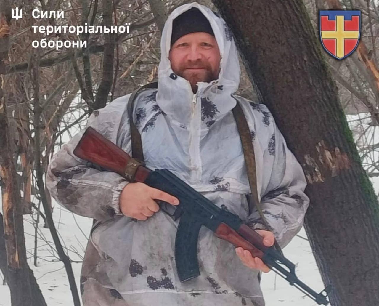 Боєць Сил оборони в зимовому маскувальному одязі з автоматом в руках