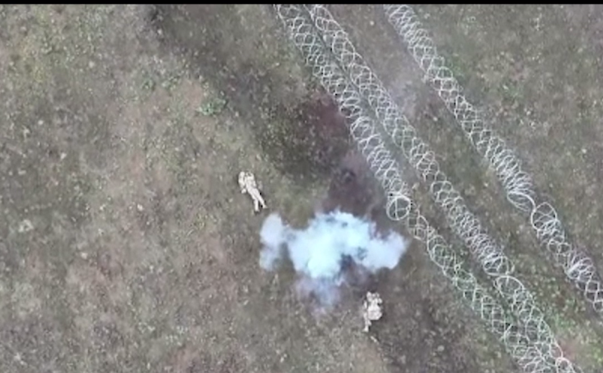 Два окупанта валються на землі, між ним дим від вибуха