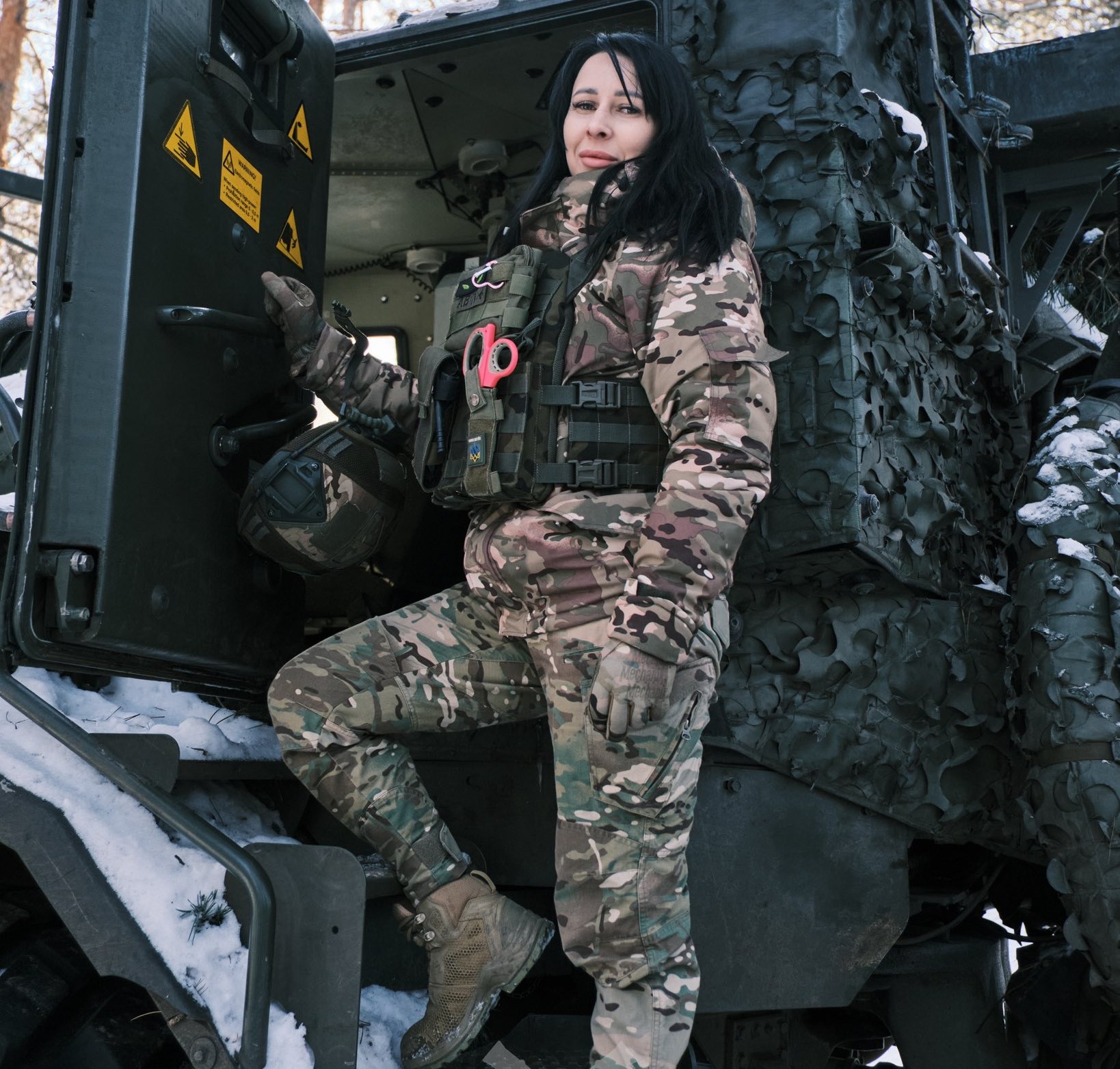 Військова ЗСУ на самохідній артилерійській установці в бронежилеті.