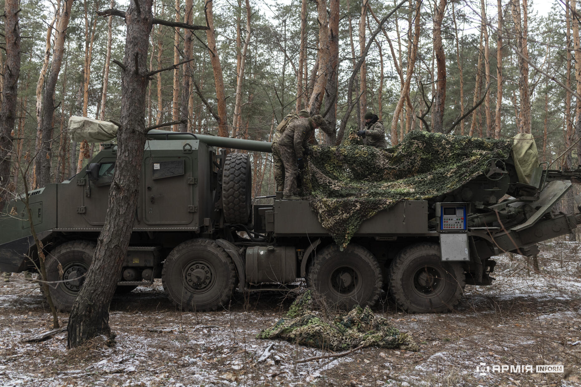Бійці ЗСУ маскують самохідну артилерійську установку.