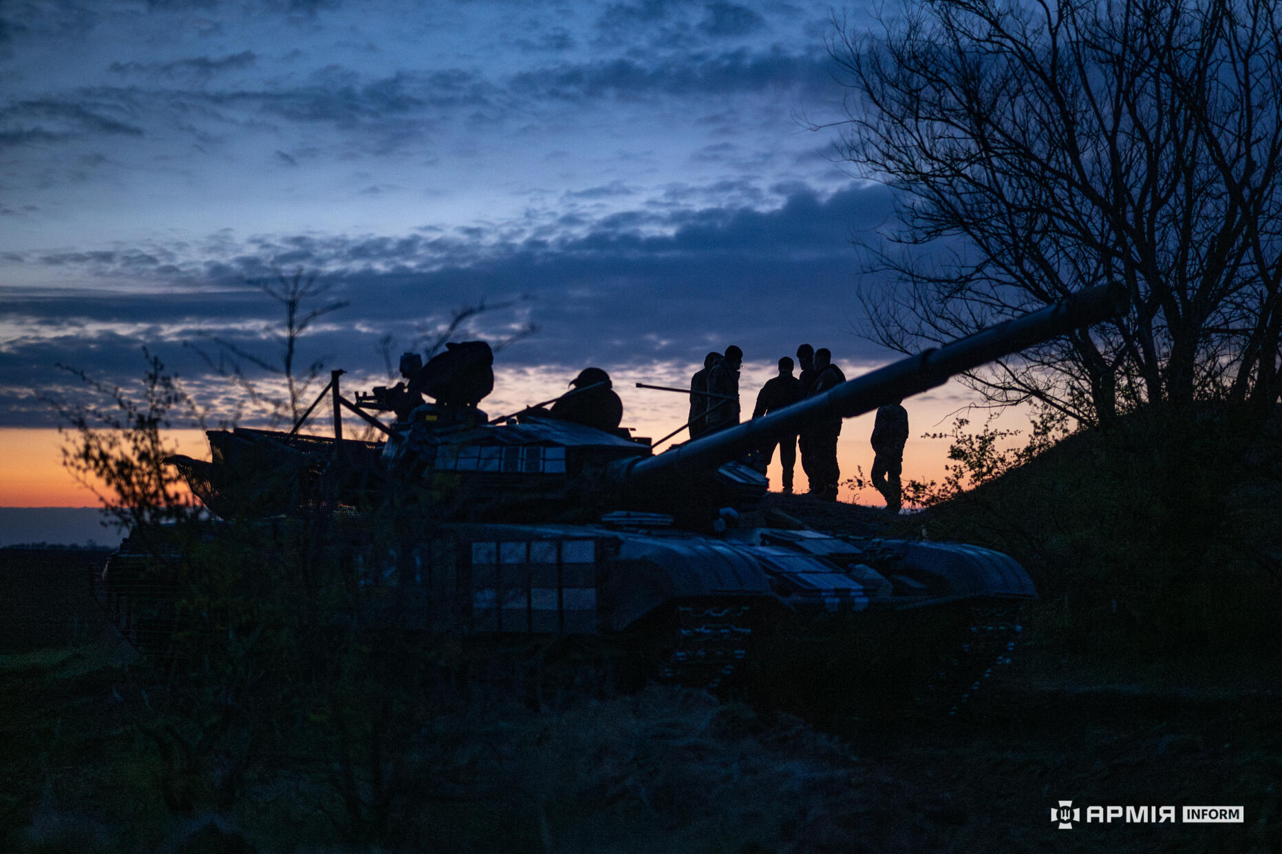 Українські танкісти на світанку стоять на броні танку Т-72