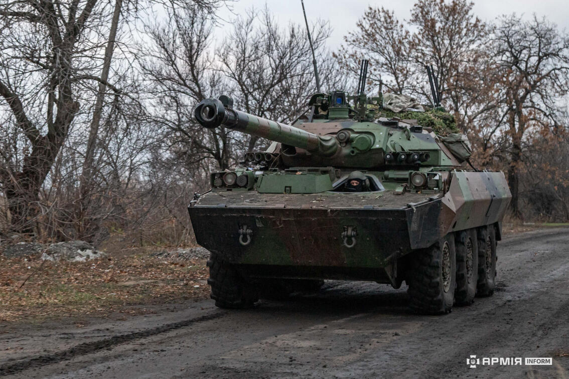 Французька колісна бронемашина AMX-10RC на розмитій грунтовій дорозі у лісистій місцевості з логотипом АрміяInform.