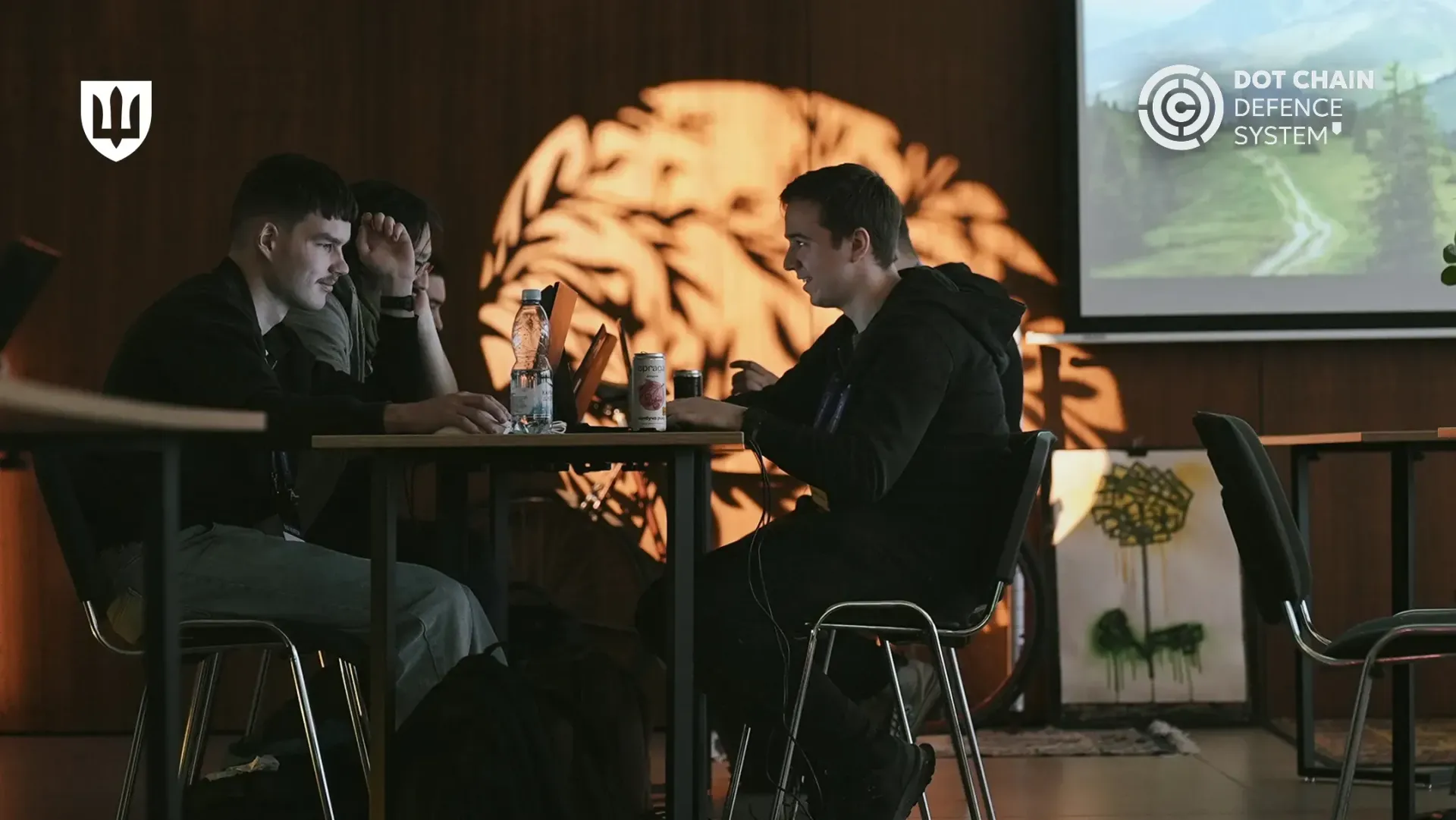 Молоді люди спілкуються, сидячи один навпроти одного за робочим столом із ноутбуками