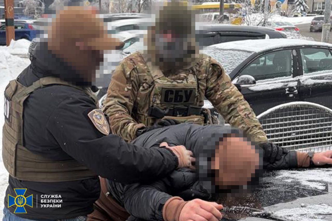 Затриманий лежить на капоті, поруч правоохоронці