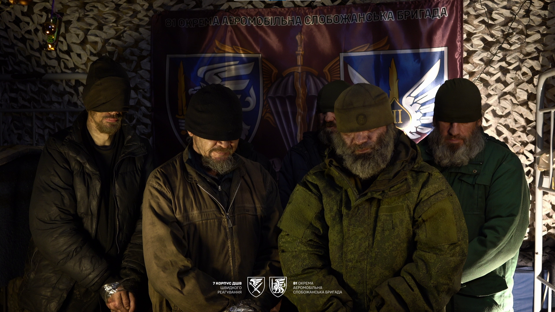 Полонені окупанти стоять під стіною