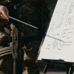 Військовий вказує на схему штурму будівель на дошці