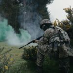 Військовий на позиції під прикриттям зеленого диму