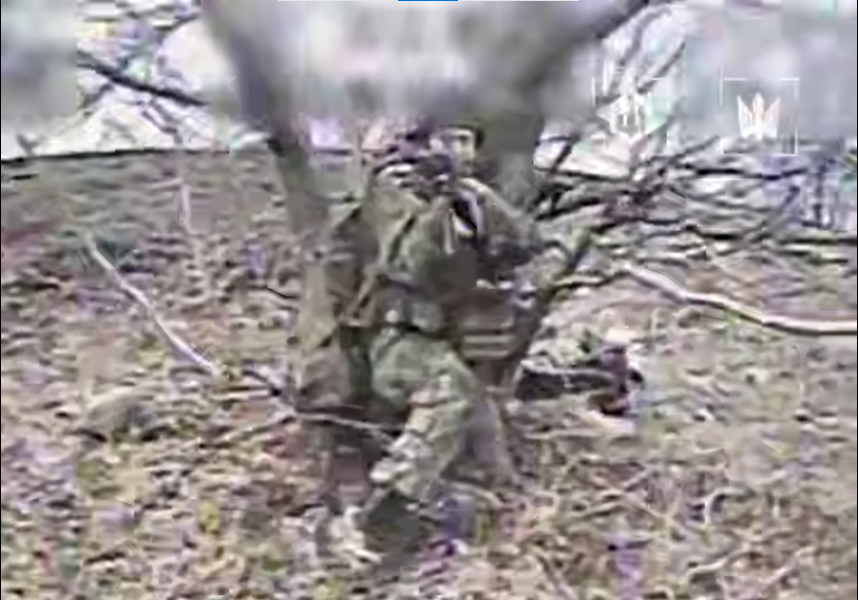 Ворожий солдат сидить у кущах і стріляє