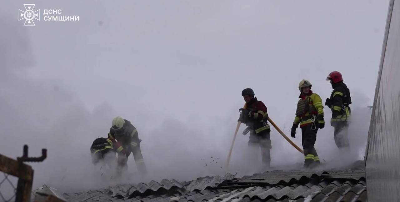 Пожежники на даху гасять полум'я внаслідок удару рф по Сумах.