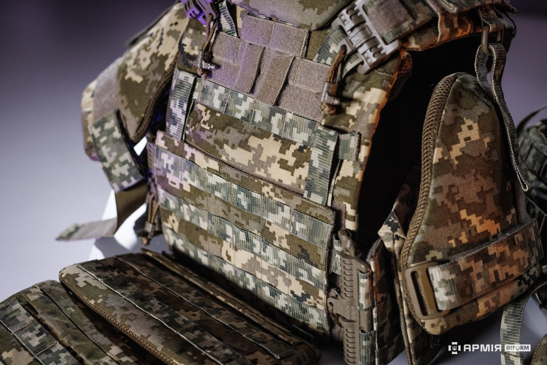 Крупний план бронежилета демонструє передню панель із системою MOLLE та кріпленнями для спорядження. Видно деталі швів і фіксаторів, що забезпечують надійність конструкції.