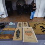 Загальний план виставкового столу показує прапори, сурму, ілюстрації одностроїв та документи періоду УНР. Експозиція присвячена українським військовим традиціям і символіці визвольних змагань.