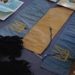 На фото крупним планом зафіксовано кілька вузьких синьо-жовтих прапорців із вишитими тризубами. Вони мають ознаки історичних пам’яток і є цінними артефактами української державності.