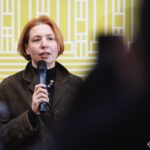 Жінка з мікрофоном звертається до присутніх під час офіційної частини заходу. Її виступ, імовірно, стосується експозиції або історико-культурного проєкту.