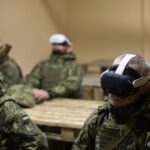 Група бійців у VR-окулярах проходить заняття в аудиторії, занурившись у віртуальну симуляцію. Їхня нерухомість і концентрація свідчать про індивідуальне опрацювання сценаріїв.
