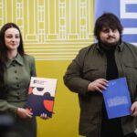 Учасники заходу позують із папками та матеріалами після вручення, демонструючи результати співпраці. Це офіційне фото підкреслює урочистий характер події.