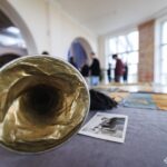 На передньому плані розташована старовинна сурма, що є частиною музейної експозиції. Композиція підкреслює увагу до військових реліквій та історичних деталей.