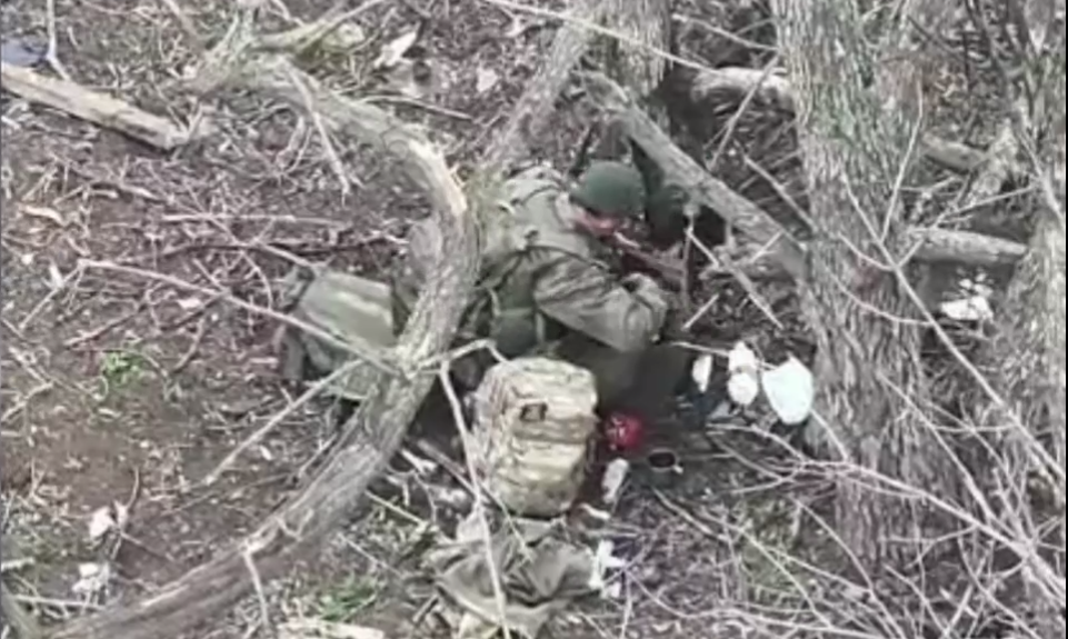 Окупант порпається у чужому наплічнику