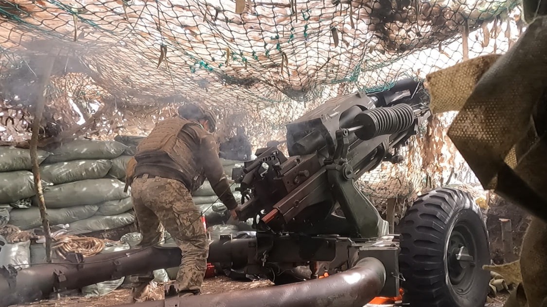 Український військовий робить постріл з гармати