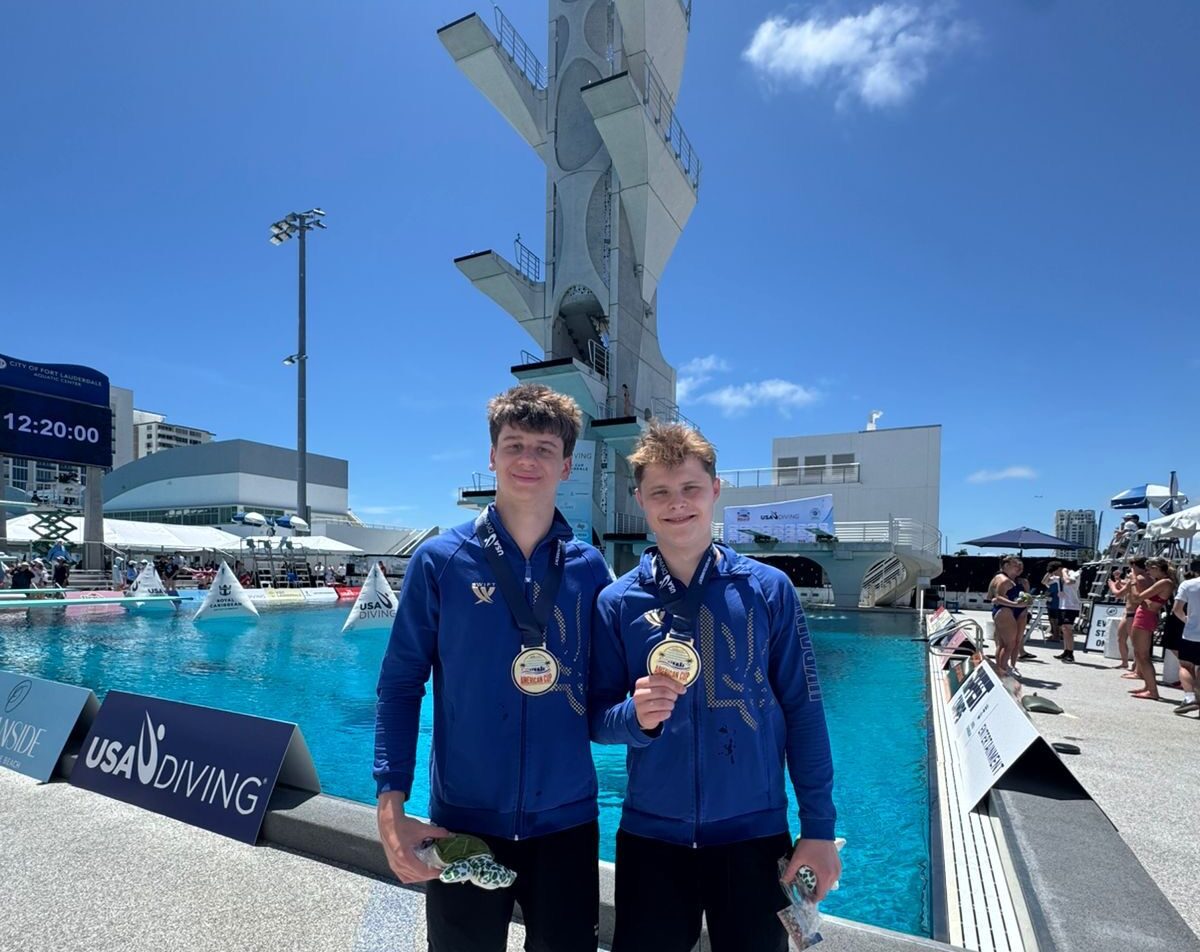 Олексій Середа тримає в рукках медаль, поруч з ним стоїть ще один спортсмен з медаллю