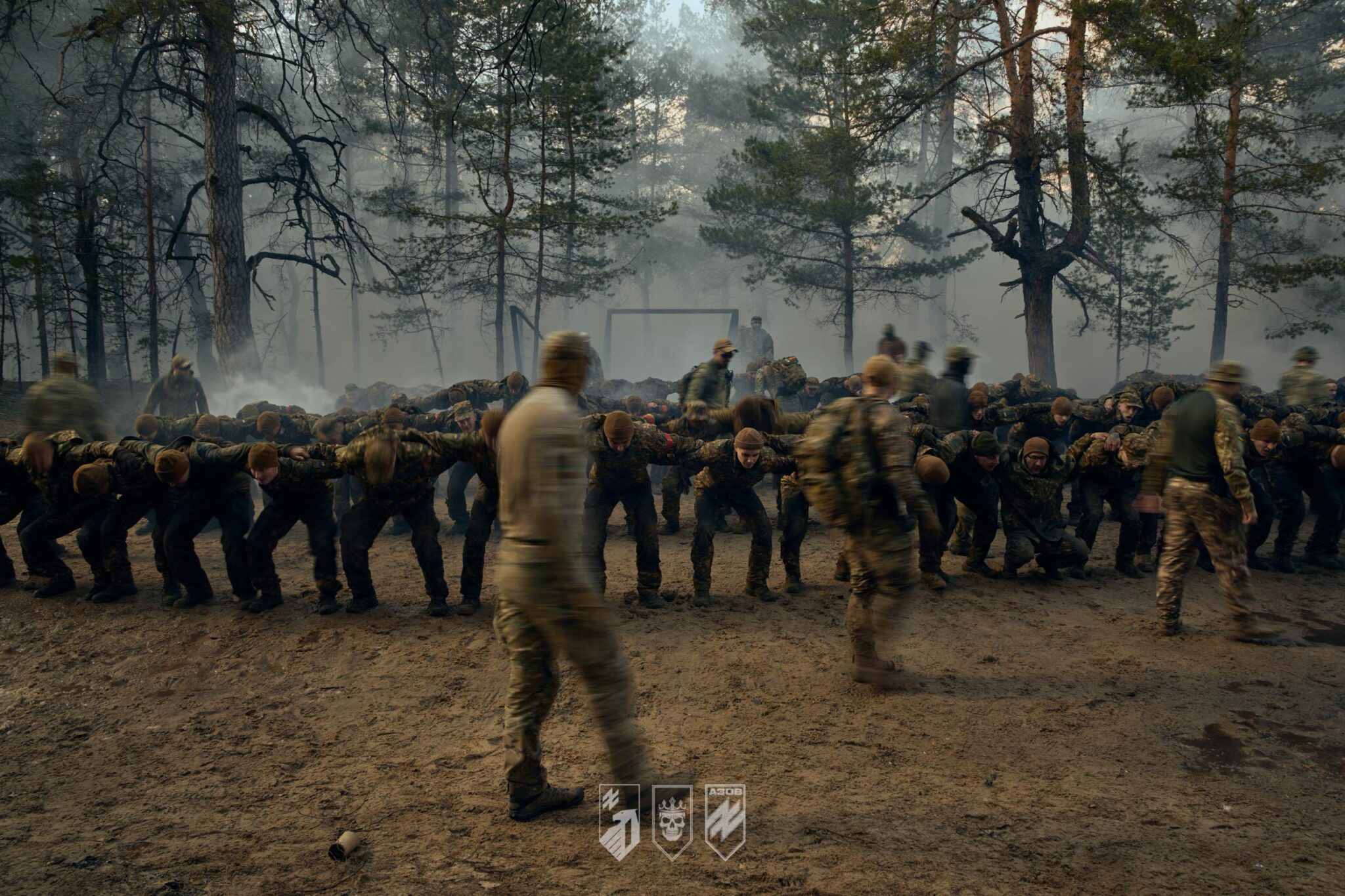 Велика кількість військових присіли і тримають один одного за плечі