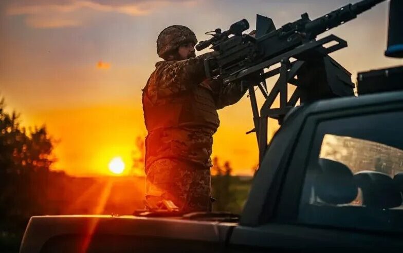Боєць мобільної вогневої групи на тлі сонця, що сідає