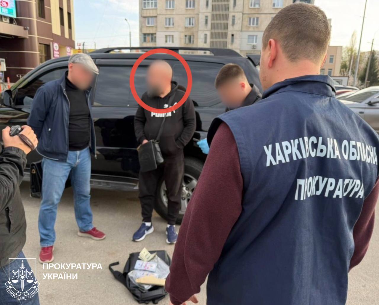 Затриманий стоїть біля авто в оточенні правоохоронців