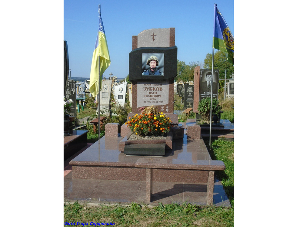 Могила Івана Зубкова оформлена великим меморіальним комплексом із портретом, прапорами та гранітним надгробком. Пам’ятник підкреслює державну шану та збереження пам’яті про полеглого захисника.