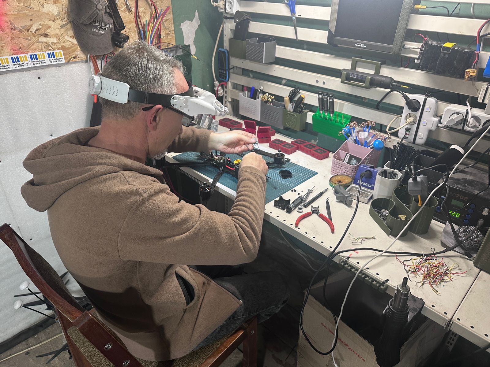 Військовослужбовець збирає FPV-дрон у військовій майстерні
