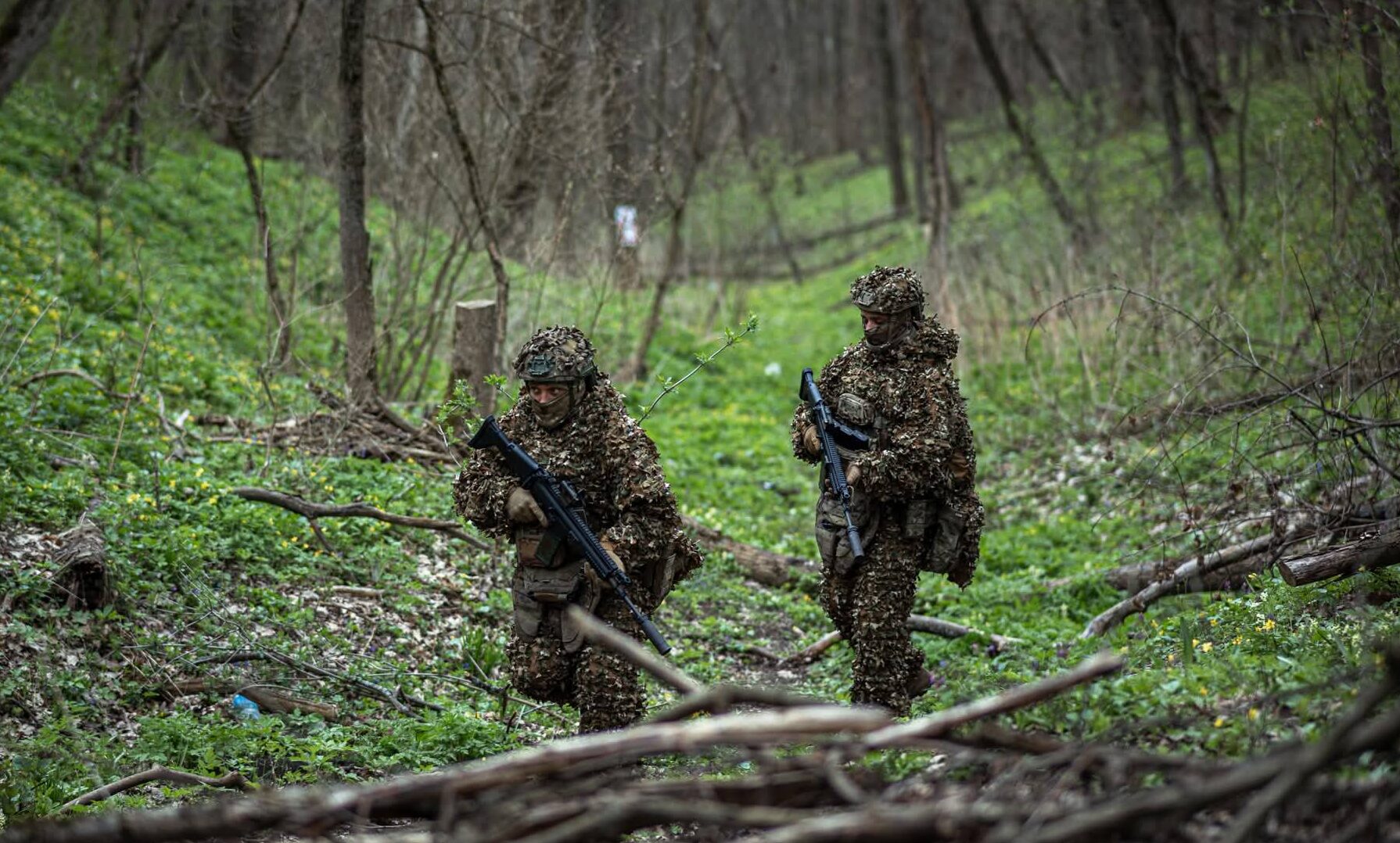 Українські воїни у маскуванні продераються через ліс