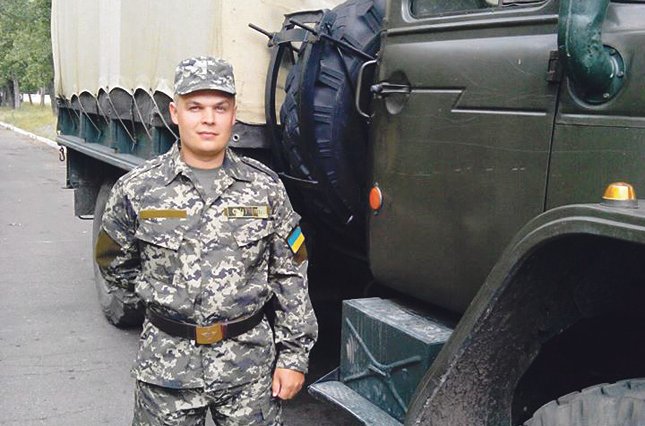 Андрій Кравченко у військовій формі біля війського автомобіля