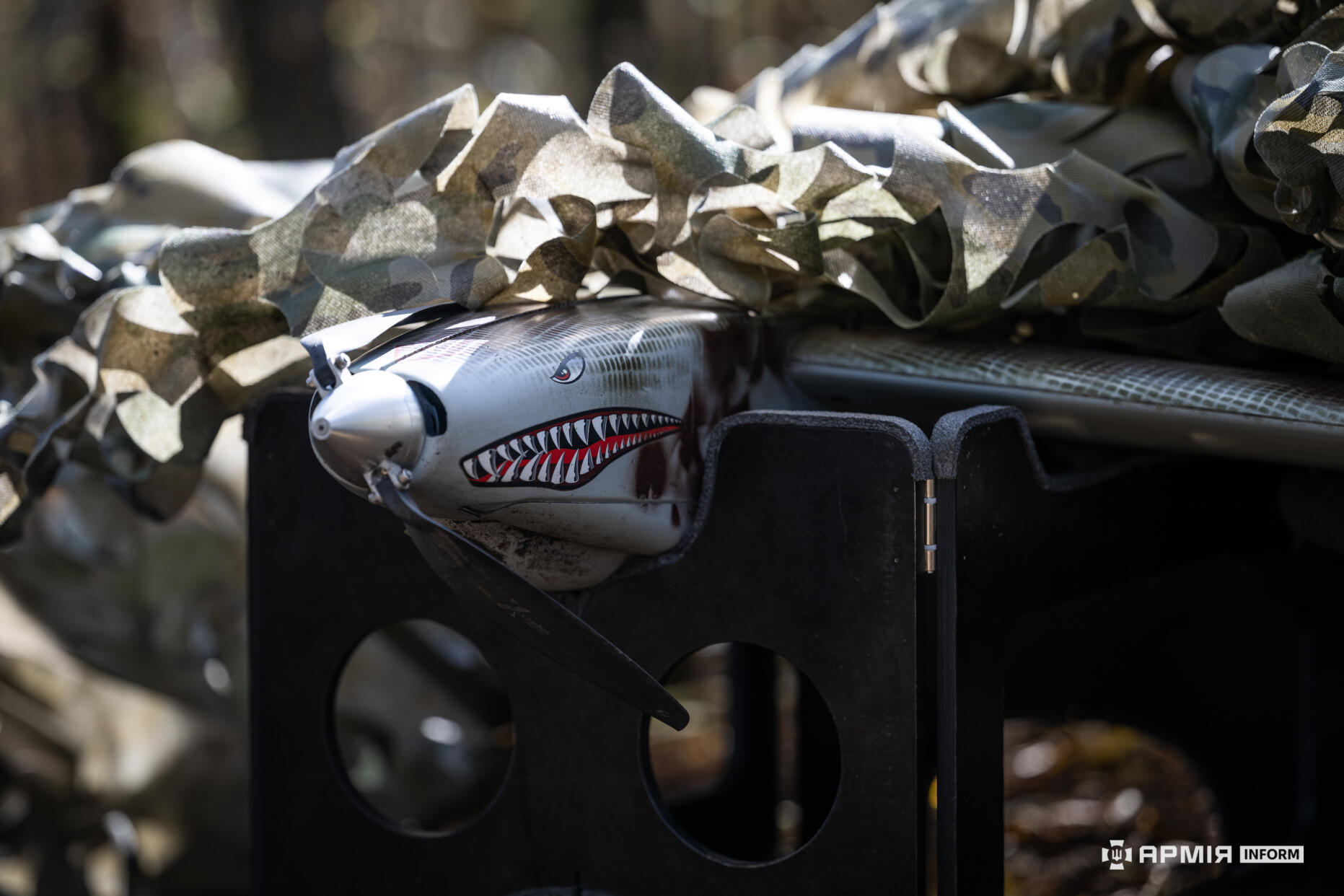 дрон Shark типу крило лежить накритий маскувальною сіткою