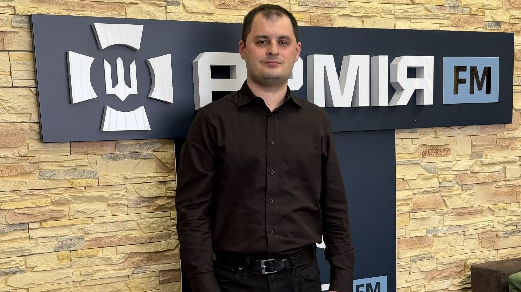 Директор програм речового майна Агенції оборонних закупівель Державного оператора тилу Микита Чічкан стоїть на тлі напису АрміяFM