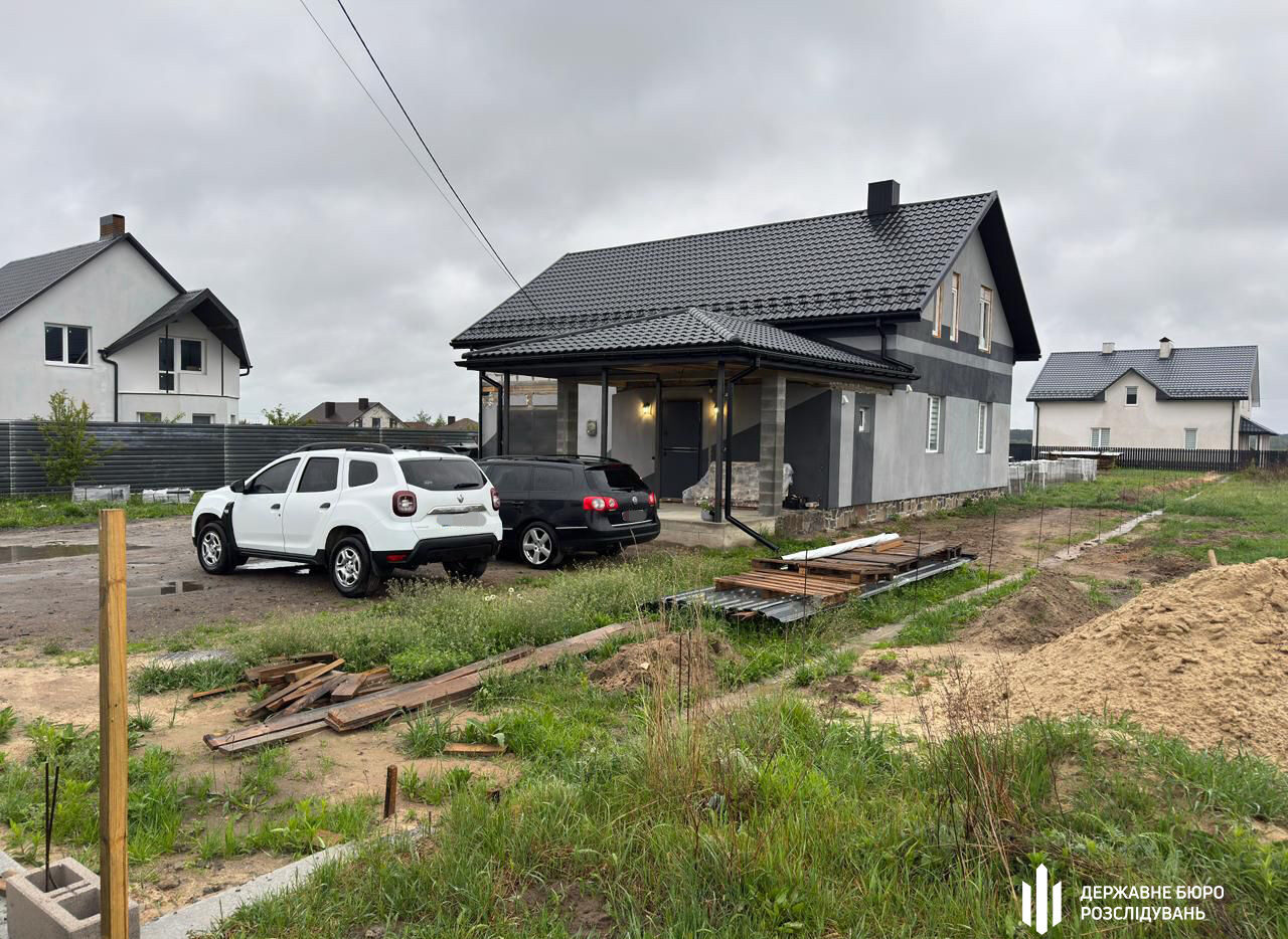 Будинок, біля якого припарковано два авто