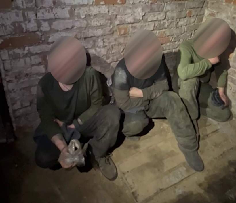 Полонені росіяни сидять під стіною