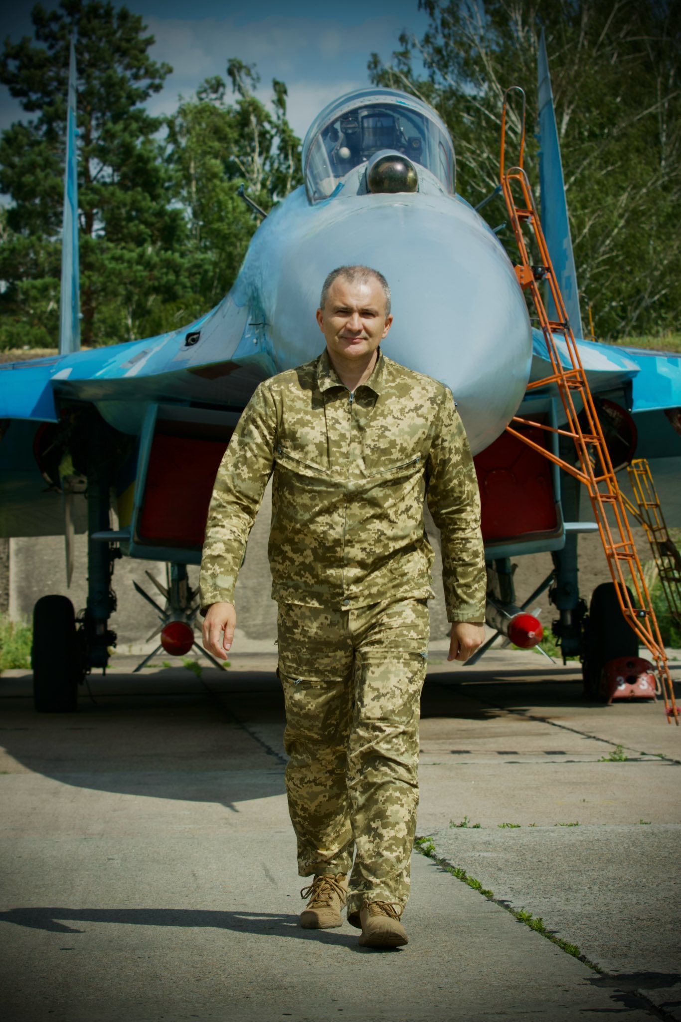 Олександр Довгач на військовому аеродромі поряд з військовий літаком