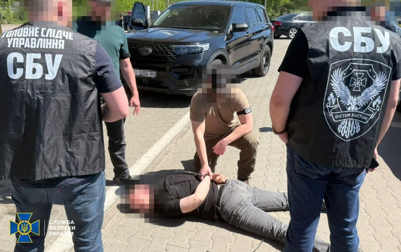 Співробітники СБУ стоять навколо затриманого, який лежить на землі