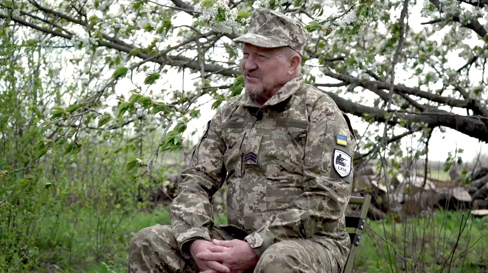 Український військовий на фоні цвітучого дерева