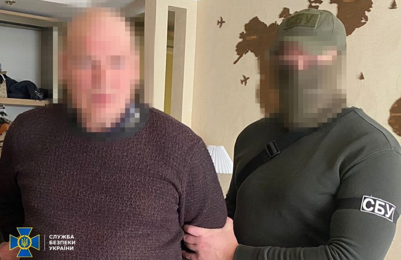 Співробітник СБУ тримає за руку підозрюваного