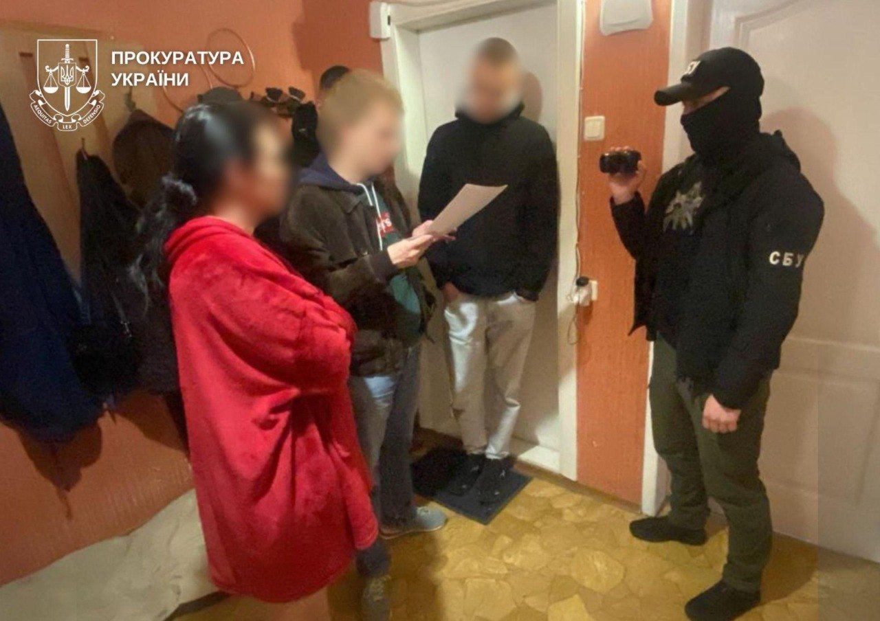 Чоловік з камерою знімає трьох цивільних